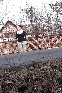 Black-haired bitch needs to piss while walking by a road