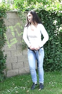 Pee sprinkles onto the grass as this miss pissing