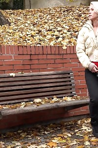 Light-haired beauty squats to pee on fallen leaves