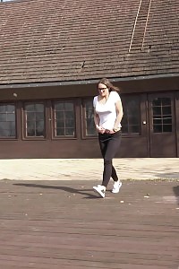 Brunette in specs pisses on wooden decking