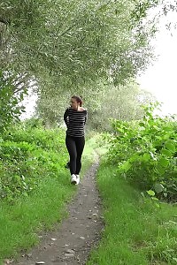 Inviting brunette squats to pee over a park path