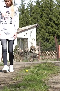 Light-haired in jeggings pisses on a dirt track