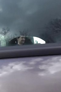 Nice-looking princess pisses behind a parked vehicle on the grass