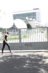 Black haired model wearing glasses pissing outside