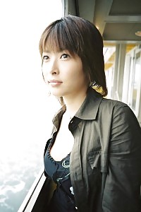 Asian bitch in a dress is jerking off and pinching her hard tits in her bed