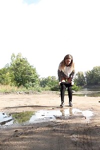 Brunette lass keeps a lookout while peeing