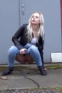 Outstanding light-haired squats on concrete to pee