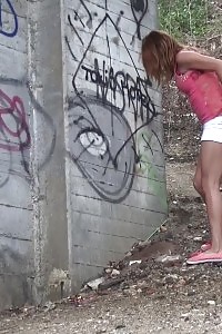 Wonderful doll crouches on the soil to piss