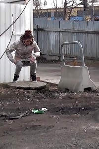 Heartwarming brunette peeing on an industrial estate