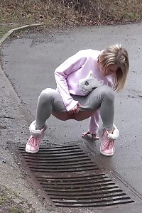 Light-haired beauty Claudia pisses down a drain outside