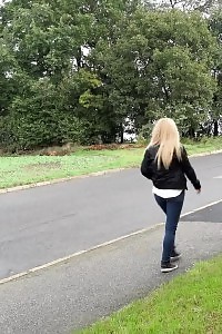 Good-looking blonde pisses next to a busy road