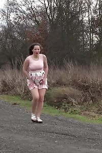 Preggo brunette pisses on the ground outdoors